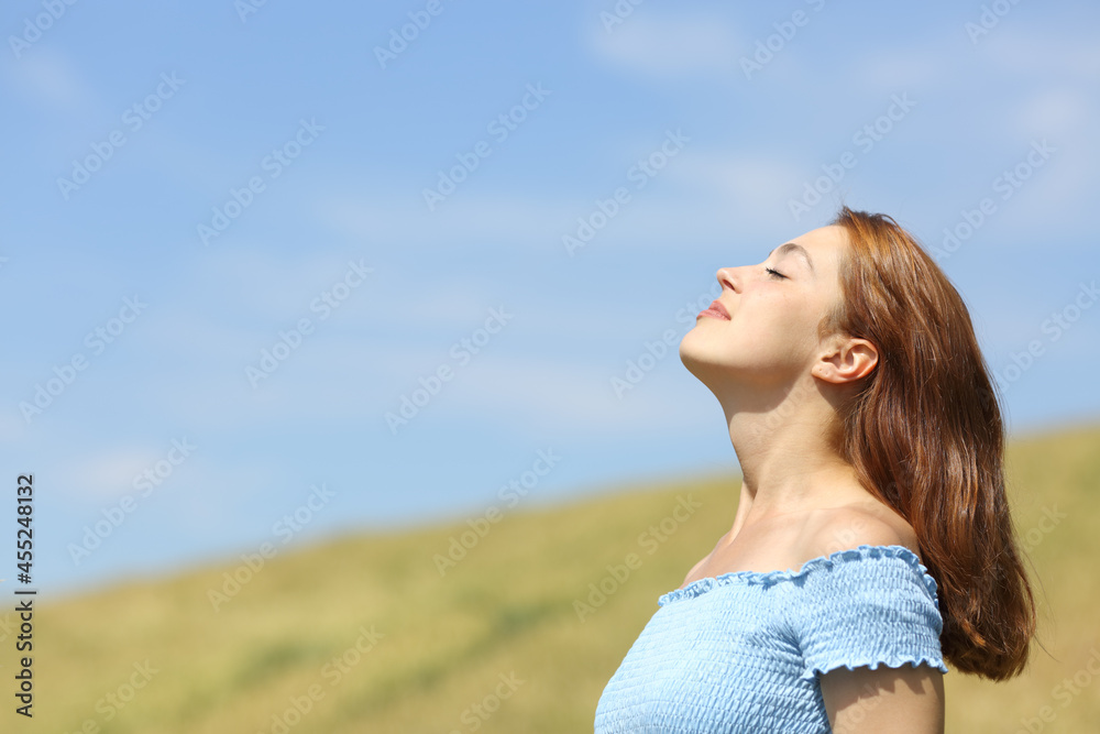 Profile of a woman breathing fresh air in a wheat field