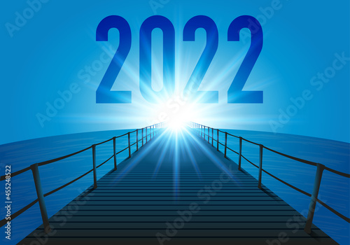 L’année 2022 avec le concept de l’objectif à atteindre pour l’avenir d’une entreprise. L’illustration utilise le symbole d’un ponton traversant l’océan en direction du soleil qui brille à l’horizon.