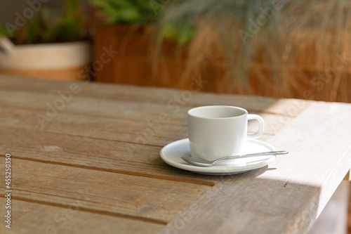 Tasse im Morgenlicht auf rustikalem Holztisch