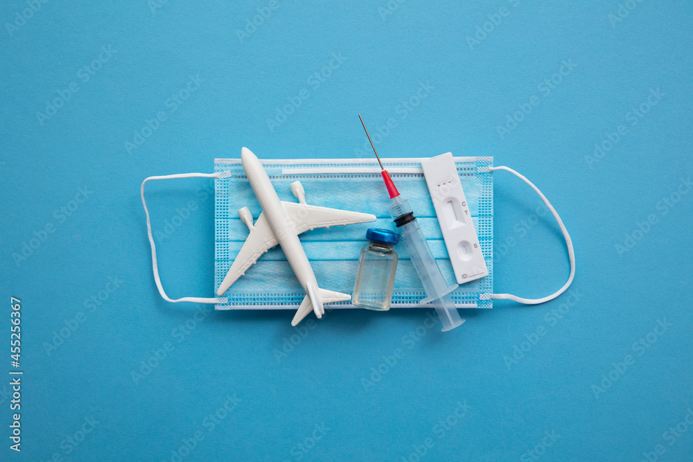 Covid air travel background. Airplane with a coronavirus protective face mask vaccine needle and test - obrazy, fototapety, plakaty 