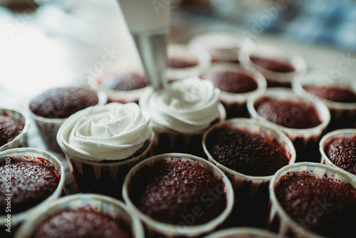 Fotografie White cream on red velvet cupcakes