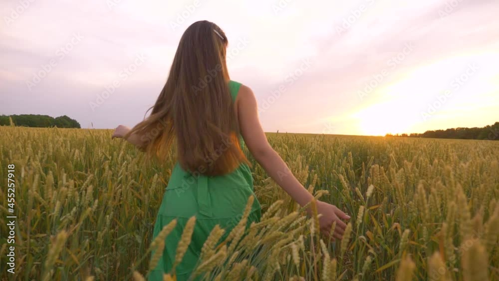 A beautiful teenager runs through a green field. Long hair develops in the wind. A girl in a green dress enjoys life, clean air. A happy child runs forward to a dream, rejoicing in a new day. A beautiful teenager runs through a green field. Long hair develops in the wind. A girl in a green dress enjoys life, clean air. A happy child runs forward to a dream, rejoicing in a new day.