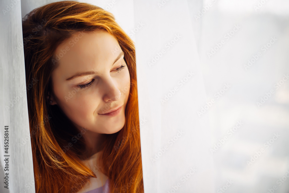 Gorgeous young redhead girl with long hair, close-up, copy space. Portrait of beautiful smiling woman with perfect skin on light blurry background. Gorgeous young redhead girl with long hair, close-up, copy space. Portrait of beautiful smiling woman with perfect skin on light blurry background.