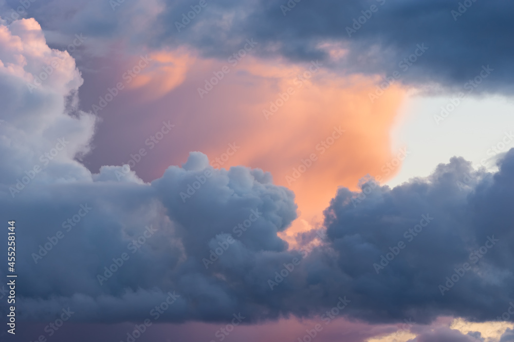 Beautiful colored dramatic stormy cumulus clouds on sky at sunset. Close-up view. Background texture