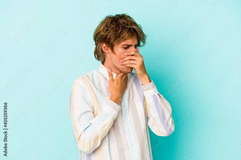 Young caucasian man with make up isolated on blue background suffers pain in throat due a virus or infection. Young caucasian man with make up isolated on blue background suffers pain in throat due a virus or infection.