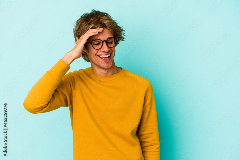 Young caucasian man with make up isolated on blue background joyful laughing a lot. Happiness concept. Young caucasian man with make up isolated on blue background joyful laughing a lot. Happiness concept.