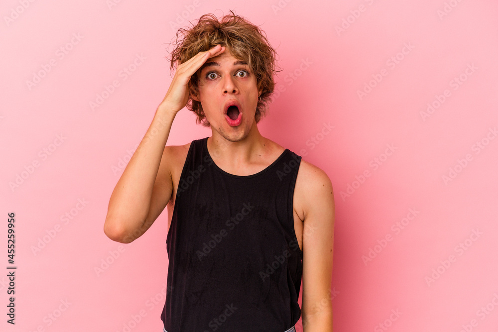 Young caucasian man with make up isolated on pink background shouts loud, keeps eyes opened and hands tense. Young caucasian man with make up isolated on pink background shouts loud, keeps eyes opened and hands tense.