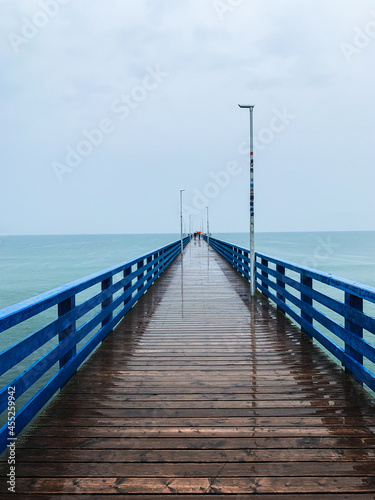 Wooden pier in the sea  gray sky background  misty rainy day