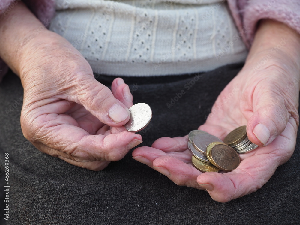 Ruble coins in the hands of a hopeless Homeless old woman, wrinkled fingers, grandmother gives money, Savings, poverty and low standard of living, pension. The global crisis is ravaging the elderly.