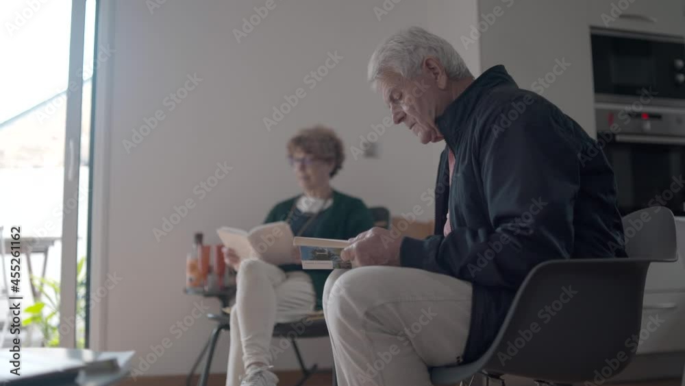 senior reading a book in a library