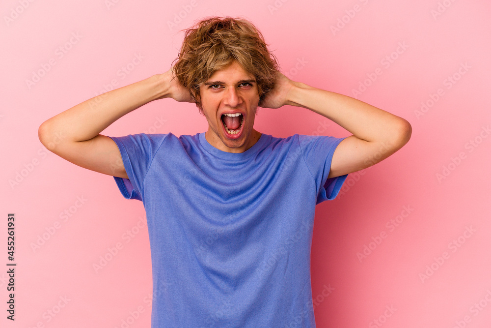 Young caucasian man with make up isolated on pink background screaming, very excited, passionate, satisfied with something. Young caucasian man with make up isolated on pink background screaming, very excited, passionate, satisfied with something.
