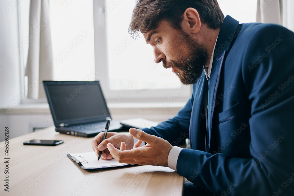 bearded man sitting at a desk in front of a laptop finance technologies bearded man sitting at a desk in front of a laptop finance technologies