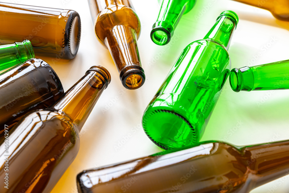 Empty beer or beverage bottles on white surface. Reuse and recycling of glass. Waste.
