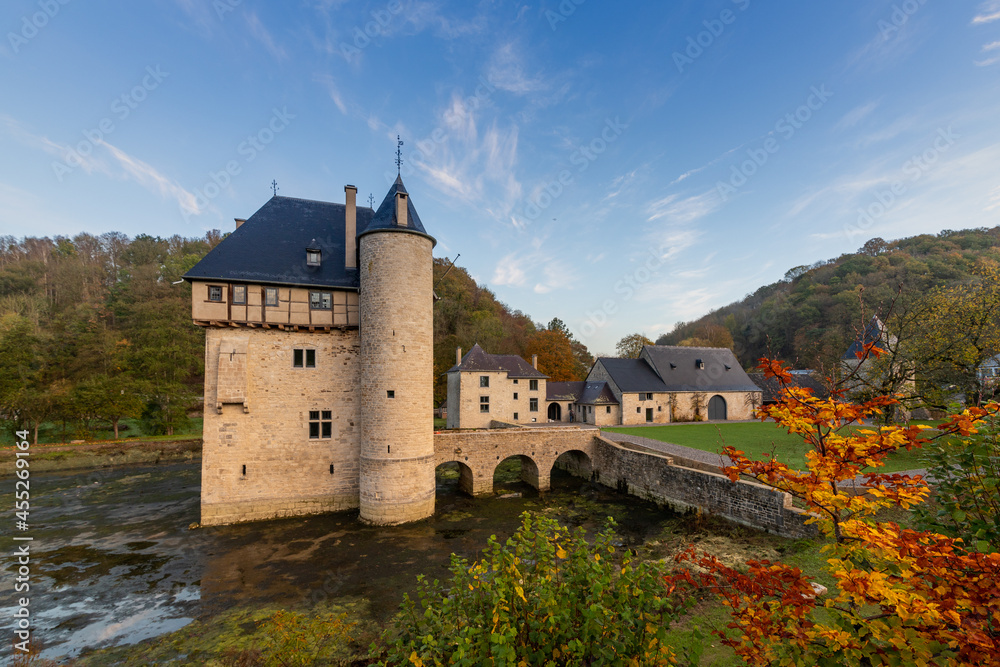 Photographie de paysage du donjon du Carondelet (château ferme de Crupet, Namur, Wallonie, Belgique) prise en automne et présentant le château dans un environnant verdoyant