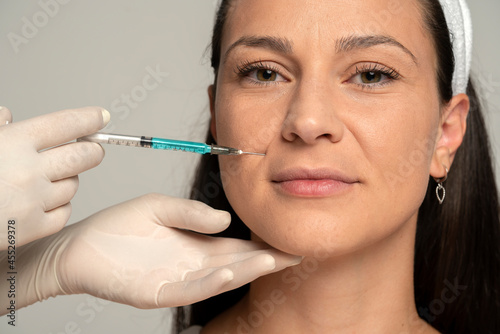 Portrait of a young satisfied woman on a face filler injection procedure