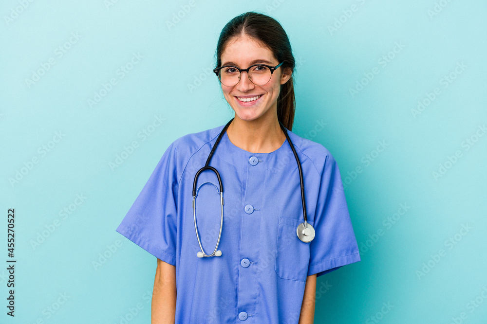 Young caucasian nurse isolated on blue background happy, smiling and cheerful. Young caucasian nurse isolated on blue background happy, smiling and cheerful.