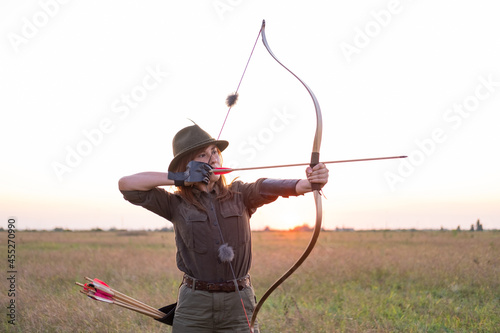 woman with bow outdoors in the field