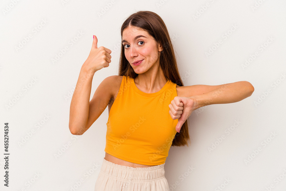 Young caucasian woman isolated on white background showing thumbs up and thumbs down, difficult choose concept Young caucasian woman isolated on white background showing thumbs up and thumbs down, difficult choose concept