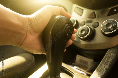 The left hand holds the car's automatic transmission inside the driver.