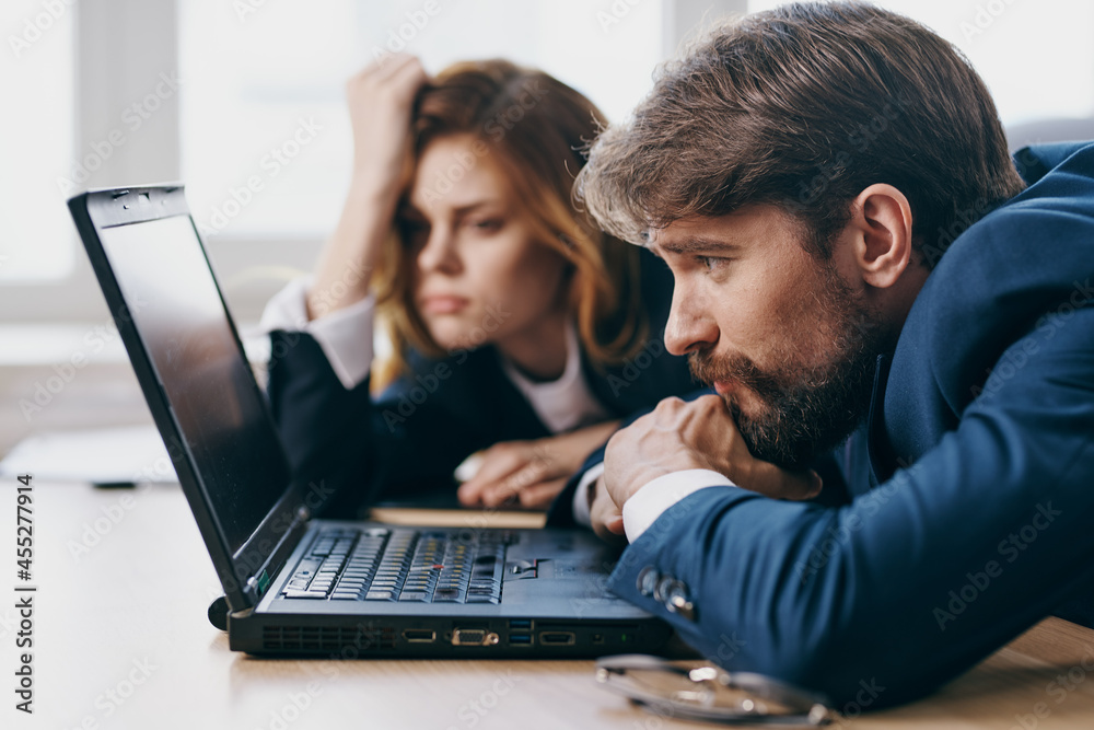 business man and woman sitting in front of a laptop teamwork officials business man and woman sitting in front of a laptop teamwork officials