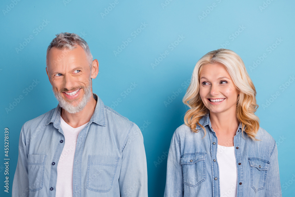 Photo of mature cheerful couple happy positive smile romantic spouses isolated over blue color background Photo of mature cheerful couple happy positive smile romantic spouses isolated over blue color background