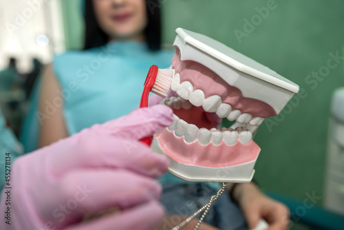 Doctor showing how to clean teeth rightly to  patient photo