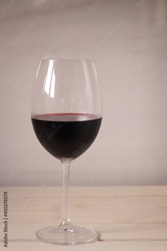 Crystal goblet containing red wine on a neutral white background. Available space to write. Crystal goblet containing red wine on a neutral white background. Available space to write.