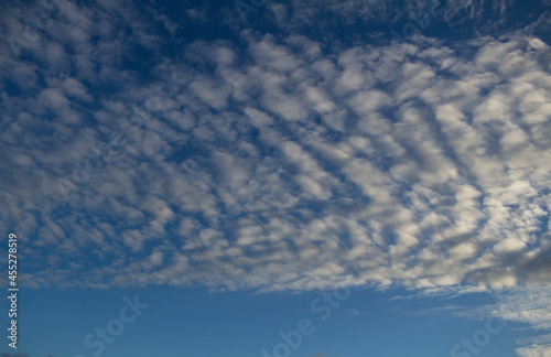 Fototapeta Naklejka Na Ścianę i Meble -  Small white clouds scattered across the sky during sunset. Designer resource