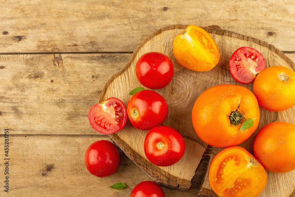 Assorted ripe tomatoes on a wooden stand. Fresh red and orange organic vegetables Assorted ripe tomatoes on a wooden stand. Fresh red and orange organic vegetables
