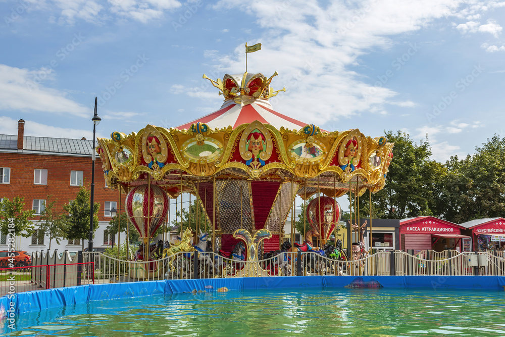 Obraz premium Bright carousel and summer pool in the amusement park on Zhitnaya square. Kolomna, Russia