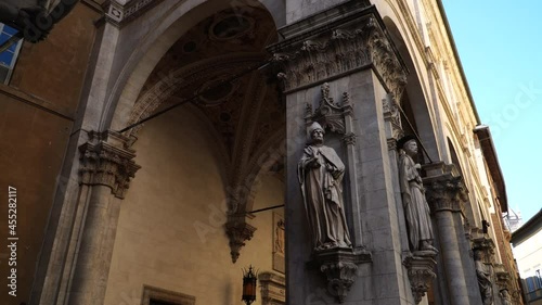 Statues on pilasters of the Loggia della Mercanzia in Siena, Tuscany, Italy. Exterior pillars of fifteenth century lodge in the old town photo