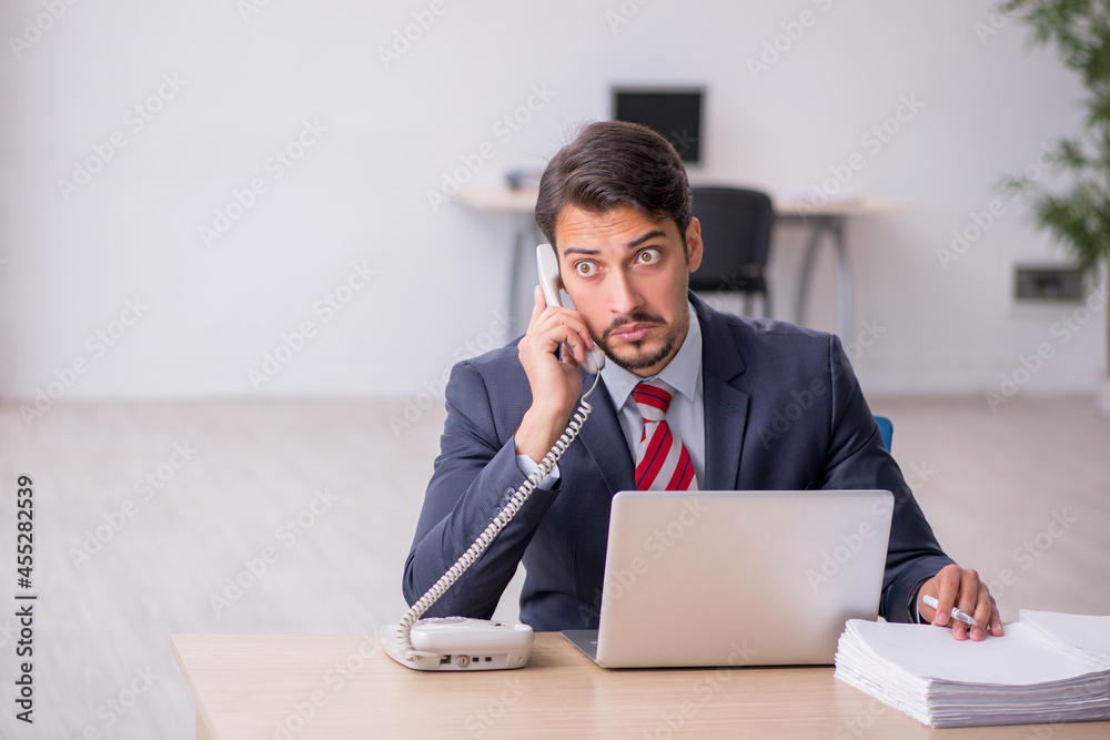 Young male employee sitting at workplace Young male employee sitting at workplace