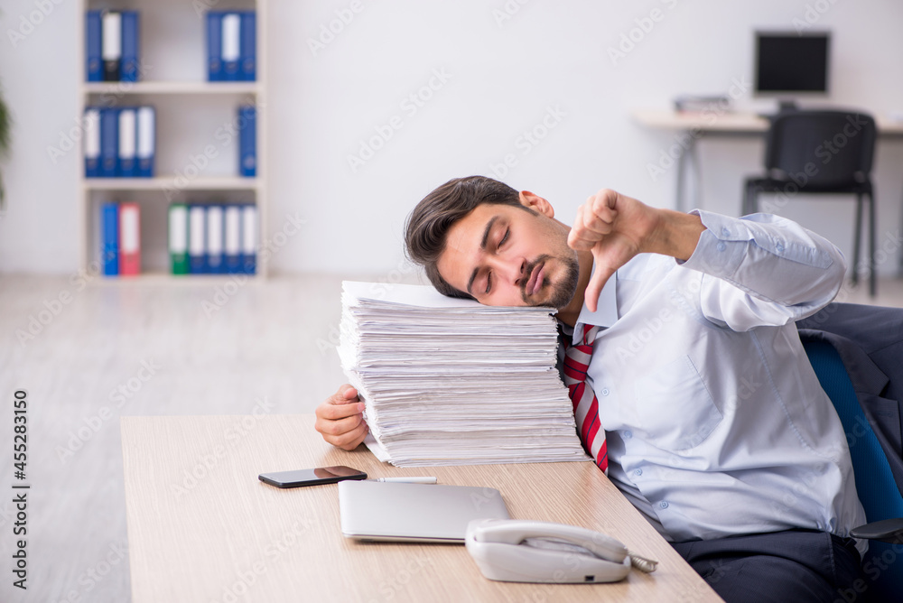 Young male employee sitting at workplace Young male employee sitting at workplace