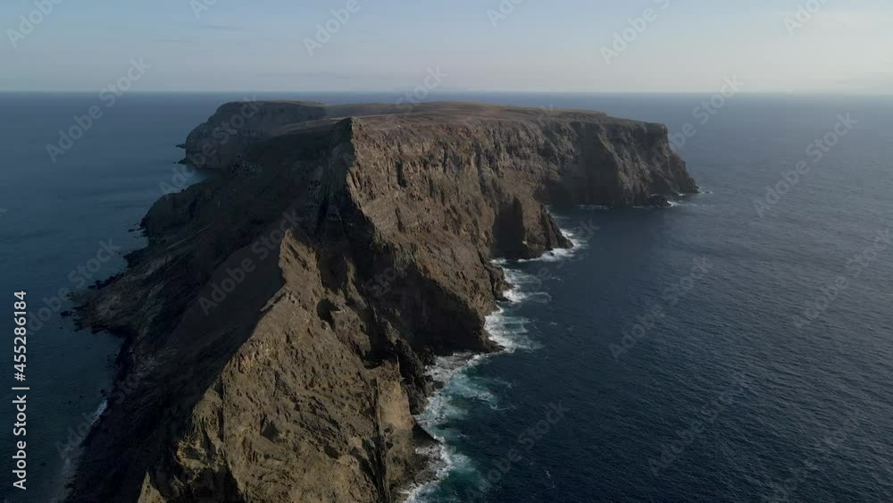 Drone flies towards the sheer cliff coastline of an island near Portugal. Drone flies towards the sheer cliff coastline of an island near Portugal.