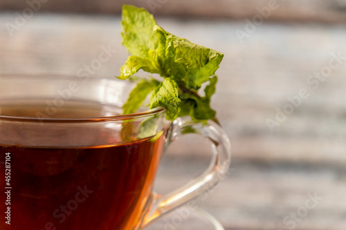 Close up shot of black tea with mint leaves on defocused background.