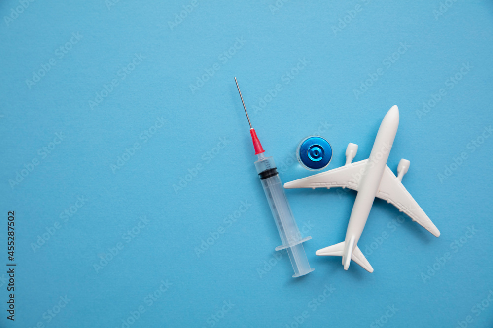 Covid air travel background. Airplane with a coronavirus vaccine needle - obrazy, fototapety, plakaty 