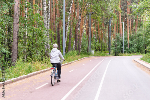 Wallpaper Mural Active senior caucasian woman with gray hair is riding bike on bicycle path in forest park. Torontodigital.ca