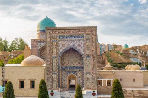 View of Shah-i-Zinda complex from entrance. Buildings and domes go up to horizon. Inscription translation: 'This building was founded by Bahadur son of Ulugbek etc'. Shot in Samarkand, Uzbekistan
