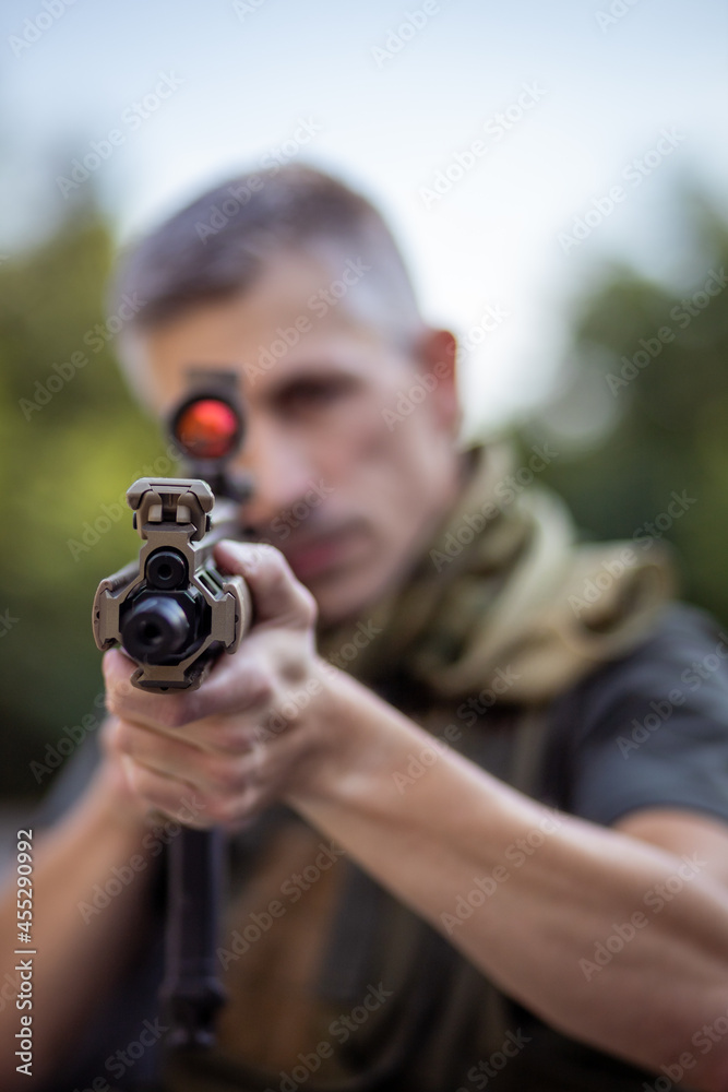 Close up of a man holding an airsoft assault rifle in military uniform Close up of a man holding an airsoft assault rifle in military uniform