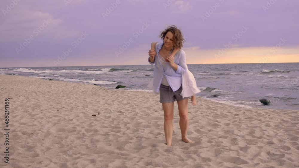 Pretty sisters daughters on the beach with smiling mother. The family people having fun on summer time. Vacation, travel, love and happiness lifestyle concept. Pretty sisters daughters on the beach with smiling mother. The family people having fun on summer time. Vacation, travel, love and happiness lifestyle concept.