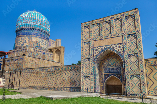 Western part of Bibi-Khanym mosque complex in Samarkand, Uzbekistan. Portal and dome of mosque decorated with oriental patterns are visible