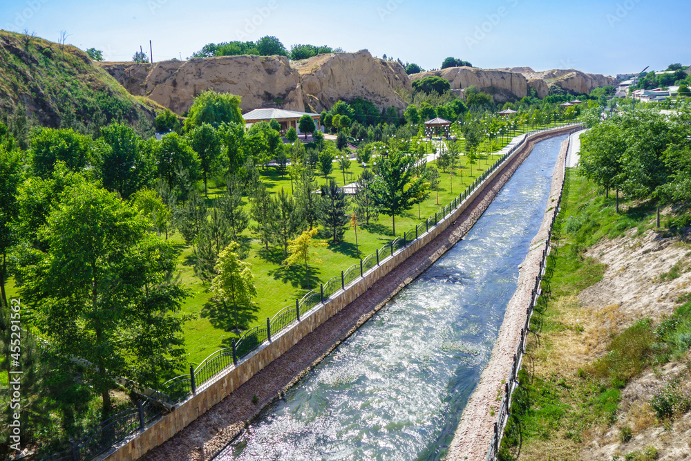 City park near Afrosiyob hill in Samarkand, Uzbekistan. Siab River flows through center. Mausoleum of prophet Doniyor is visible in distance