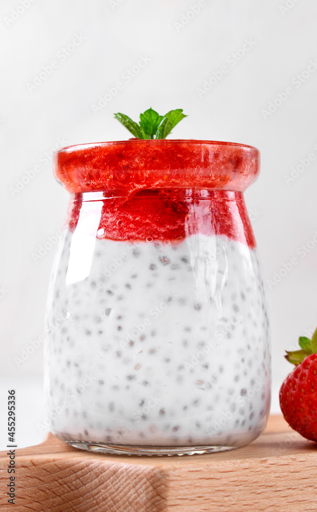Chia pudding with coconut milk and strawberry puree served in the glass jar. Healthy layered dessert. Vegan food Chia pudding with coconut milk and strawberry puree served in the glass jar. Healthy layered dessert. Vegan food