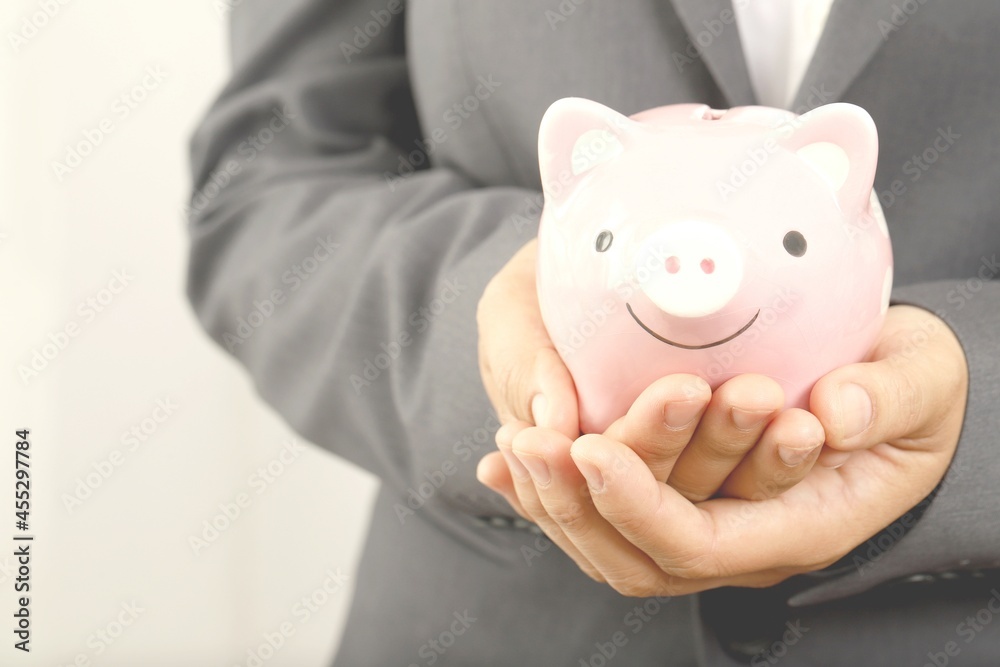 A businessman who has savings with a piggy bank A businessman who has savings with a piggy bank