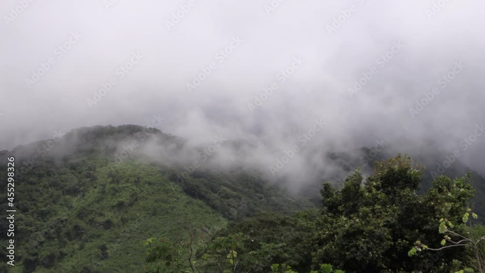 Low gray clouds, haze passing through the mountains and hills of green grass. Low gray clouds, haze passing through the mountains and hills of green grass.