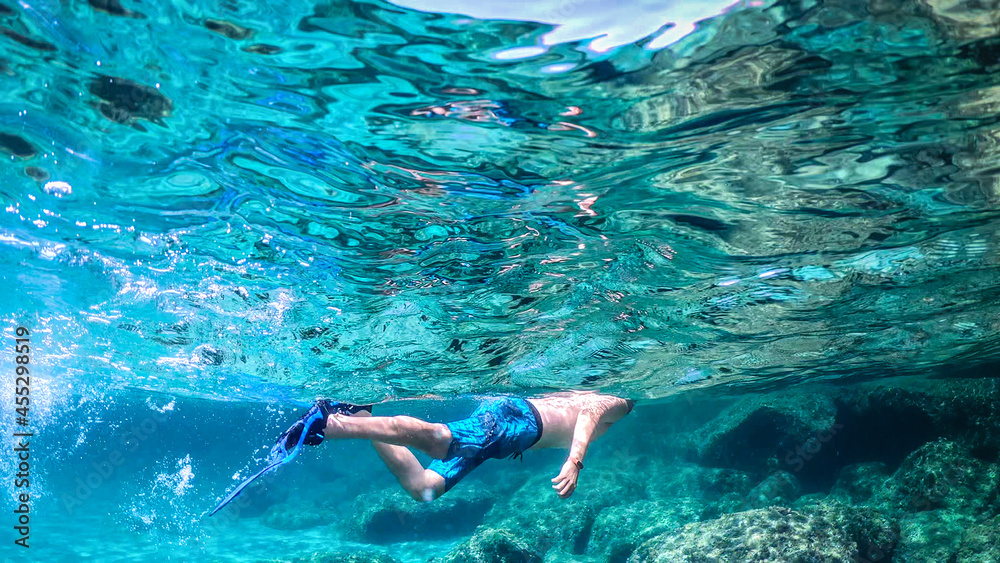 Man snorkeling in the blue sea in Sardinia