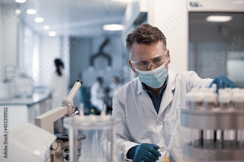 Male scientist looking at test samples in a laboratory photo