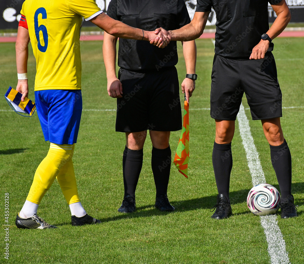 Soccer referees and a player handshake Soccer referees and a player handshake