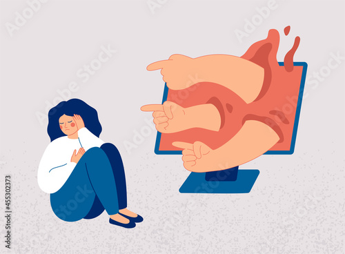 Sad woman turns away, covers her face with her hand from hands pointing at her from computer screen. Peers engage in bullying behavior towards girl. Cyberbullying concept, bad influence on internet.