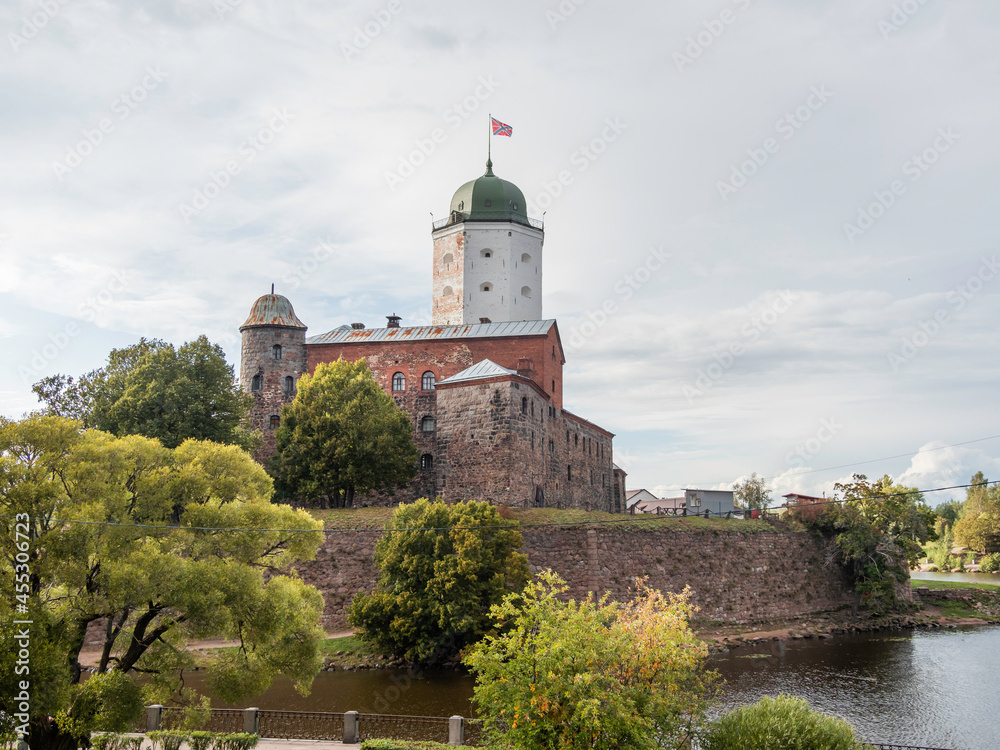 Medieval Vyborg Castle is Swedish-built fortress. White tower of Saint Olav with flag. Historical and architectural landmark in Russia.